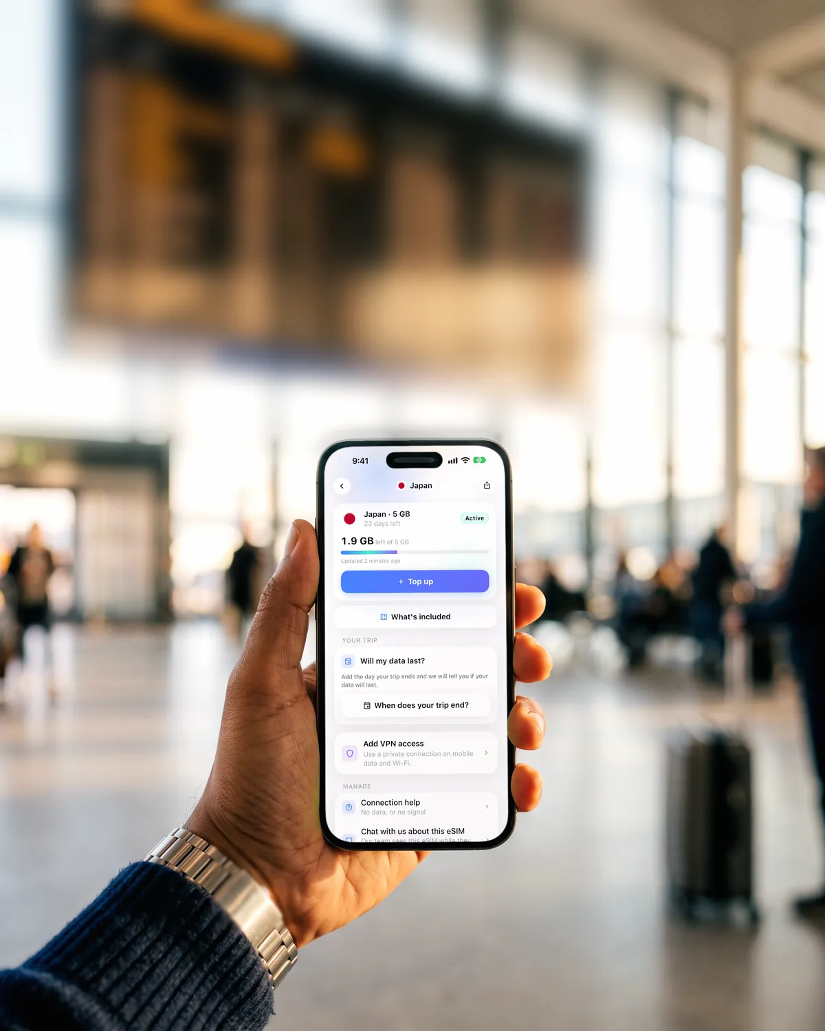 Traveller at an airport departures board checking an eSIM plan in the SimFuse app